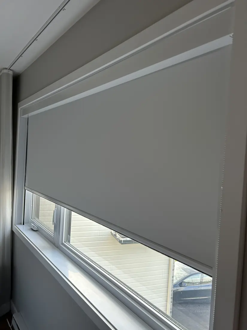 Toile opaque descendue aux deux tiers d'une grande fenêtre